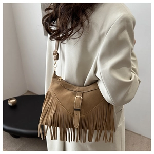 Close-up of brown suede tassel shoulder bag with metallic buckle and fringe details