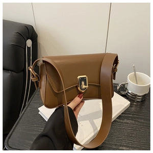 Detail of vintage brown leather handbag with gold metal twist lock and wide shoulder strap