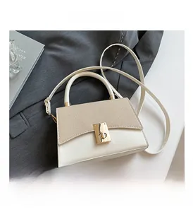 Detail showing cream contrast handbag with textured flap and gold twist-lock closure
