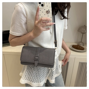 Sac bandoulière carré gris chic en tissu texturé porté par un mannequin au style minimaliste