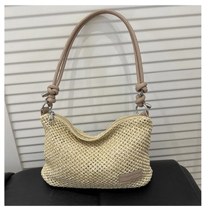 Détail d'un sac à main en paille tressée avec bandoulière nouée et fermeture éclair