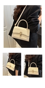 Detail of off-white crossbody bag with woven texture, golden buckle and top handle