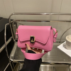 Pink crossbody bag with a wavy flap and gold rotary lock, featuring a wide shoulder strap
