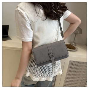 Détail de la texture en tissu gris et boucle carrée sur le sac bandoulière vintage
