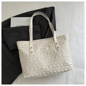 Detailed macro view of woven beige tote bag featuring geometric hollow patterns