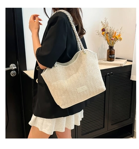 Detail of beige straw tote bag with thick rope straps and Fashion Bags label