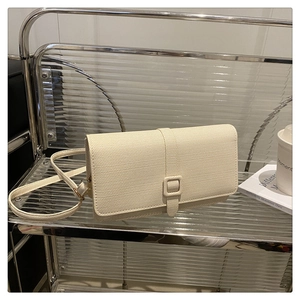 Détail du petit sac bandoulière crème minimaliste avec texture textile sur présentoir