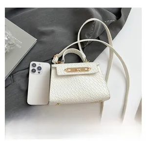 Detailed comparison of white croc-effect mini bag size with an iPhone smartphone