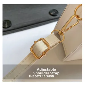 Détail de la bandoulière réglable en cuir blanc cassé avec boucle en métal doré poli