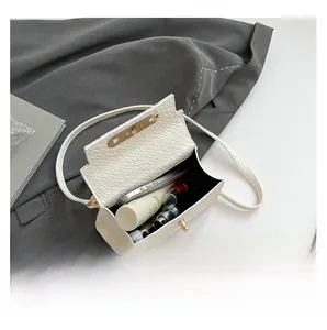 Detail view showing white crocodile pattern handbag capacity with phone and cosmetics