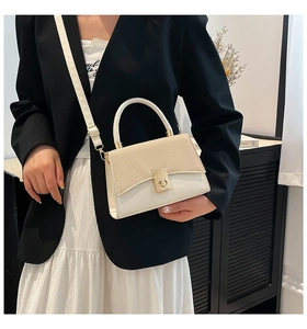 Detail of model wearing a beige contrast small square bag with gold twist lock