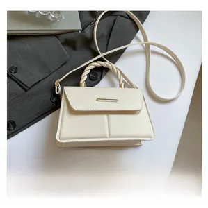Détail d'un sac bandoulière en cuir beige avec poignée tressée et fermoir doré chic