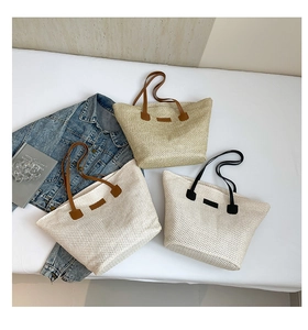 Vue détaillée de sacs cabas tissés montrant des poignées en cuir et textures en trois couleurs