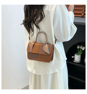 Close-up of brown textured patchwork handbag with silk scarf wrapped on the handle