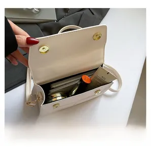 Vue intérieure du sac à bandoulière en similicuir blanc montrant l'espace de rangement