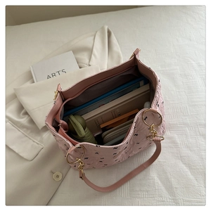 Pink bow tote bag detail showing spacious interior with books, umbrella, and golden zipper