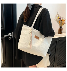 Sac fourre-tout tissé blanc avec pompon et détail en cuir porté à l'épaule