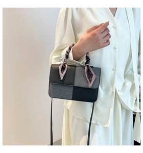 Detail of color-block mini bag featuring scarf-wrapped handle and leather texture