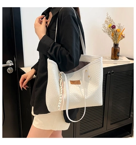Détail du grand sac cabas blanc tissé avec étiquette en cuir marron et pompon