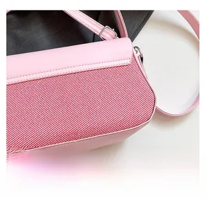 Détail du cuir rose et du tissu rouge sur un sac à bandoulière élégant pour femmes
