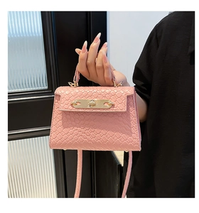 Detail of pink woven leather mini handbag with gold twist lock and slim shoulder strap