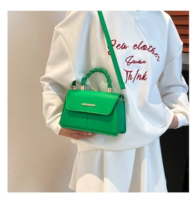 Détail du sac bandoulière vert avec poignée spirale tressée et finitions dorées chic