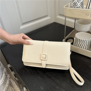 Pochette beige minimaliste en tissu tressé avec dragonne et boucle élégante pour femmes