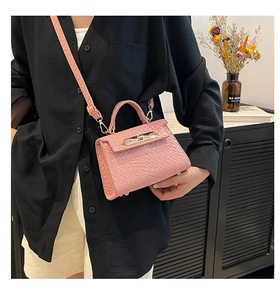 Detail of pink croc-textured mini Kelly bag with gold buckle and top handle design