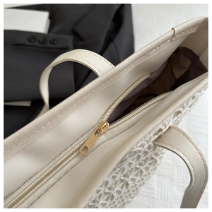 Close-up of summer straw tote bag featuring smooth zipper closure and fabric lining