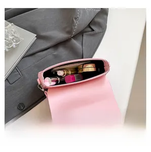 Intérieur du sac à bandoulière rose montrant l'espace pour téléphone et maquillage