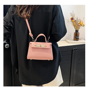 Detailed view of pink woven leather mini crossbody bag with gold hardware and strap
