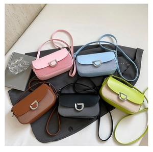 Vue à plat de petits sacs à bandoulière tissés en cinq couleurs avec fermoir en métal en D