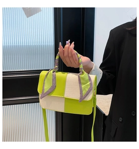 Detail of green and white patchwork handbag with silk scarf wrapped around handle