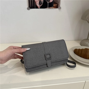 Petit sac carré vintage gris foncé avec texture sergée dans un décor intérieur élégant