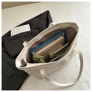Detail of hollow woven tote bag showing large capacity for laptop, wallet and umbrella