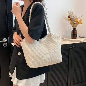 Large cream straw tote bag with double rope handles and fashion label for beach or daily use