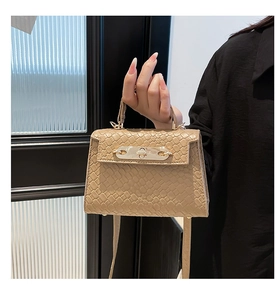 Detail of khaki snake embossed leather mini handbag with golden metal twist lock and handle