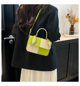 Neon green and beige contrast crossbody bag with houndstooth handle on black blazer