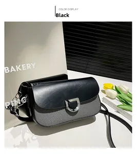 Détail du sac à bandoulière bicolore noir et gris avec boucle en D argentée et texture