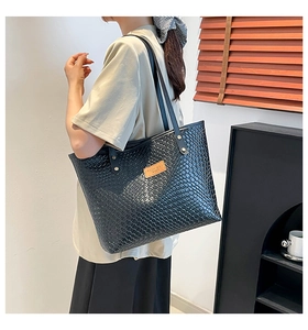 Détail du sac fourre-tout en cuir tressé noir avec logo marron et longues bandoulières