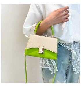 Detail of neon green contrast handbag with woven flap and metallic swivel lock