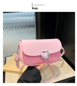 Détail du sac bandoulière à rayures roses avec boucle fer à cheval argentée et sangle