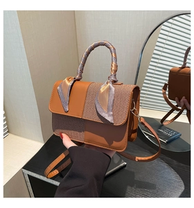 Detail of brown PU leather and woven patchwork bag with houndstooth silk scarf handle