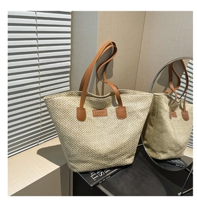 Gros plan sur le sac fourre-tout tissé beige avec anses en cuir et étiquette Fashion