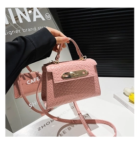 Macro shot of pink woven texture and golden metal buckle on a mini designer handbag