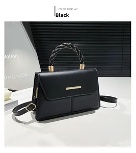 Détail du sac bandoulière noir avec poignée tressée et boucle en métal doré chic