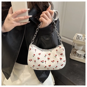 Détail du sac bandoulière blanc avec motif cerise et bandoulière en chaîne argentée