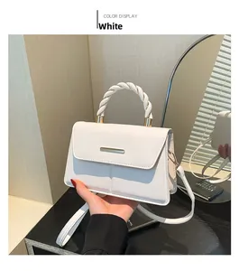 Détail du sac à bandoulière blanc avec poignée tressée et garniture dorée
