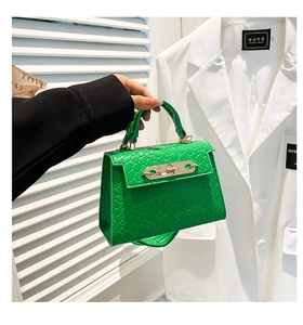 Detailed view of the lime green crocodile pattern leather mini handbag with gold lock