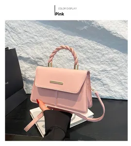 Détail de sac à main en cuir rose avec poignée tressée et garniture dorée